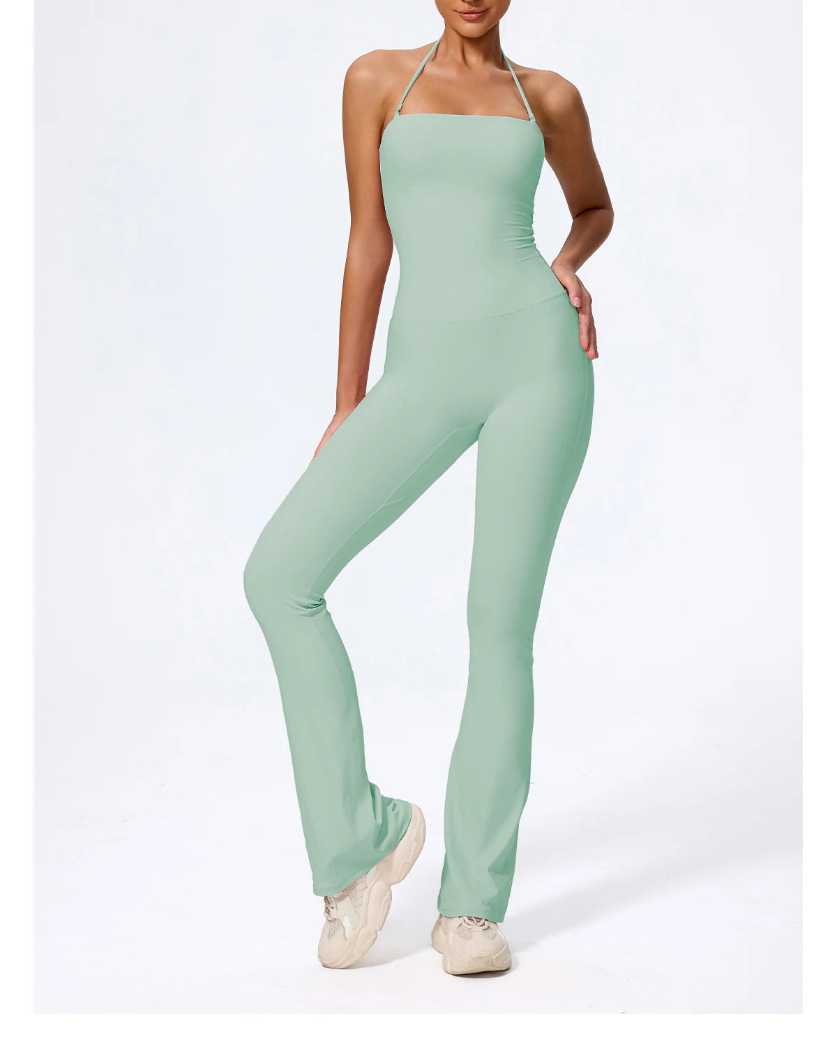 Sage jumpsuit in green, three-quarter view showing the flared hem