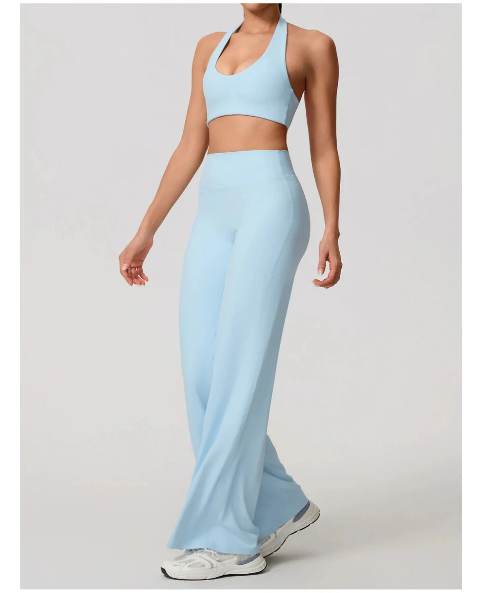 Cloud blue pilates outfit with open back halter bra and wide leg trousers, front, arm out
