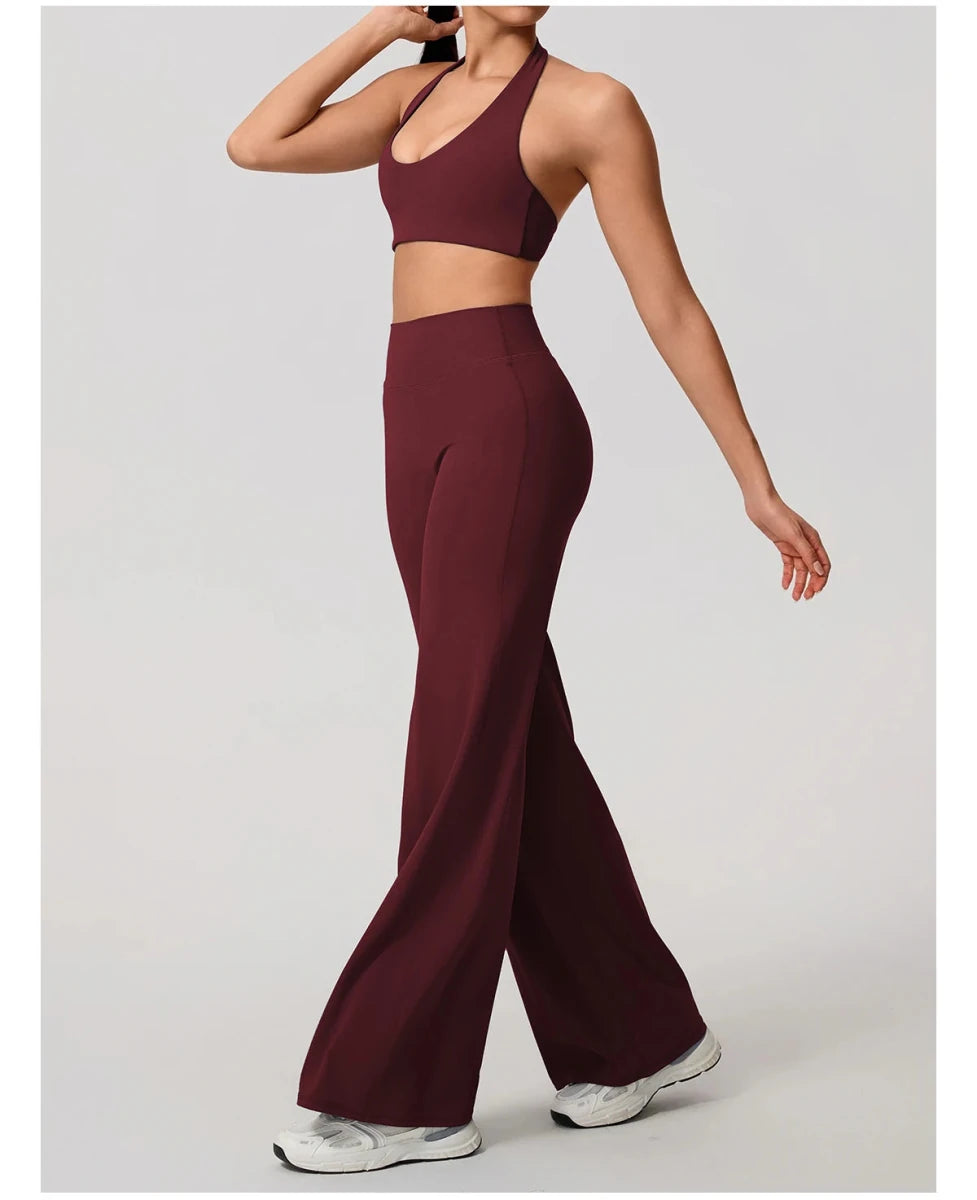 Rouge red pilates outfit with open back halter bra and wide leg trousers, front, arm out