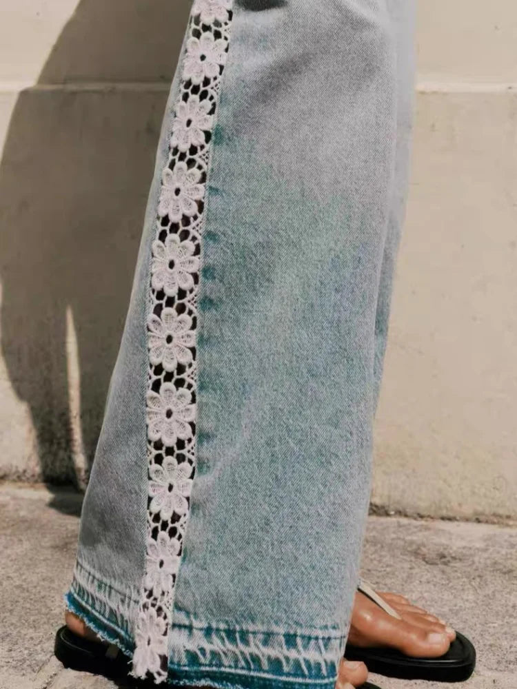 Close up of crochet lace trim on the outer seam of light wash jeans