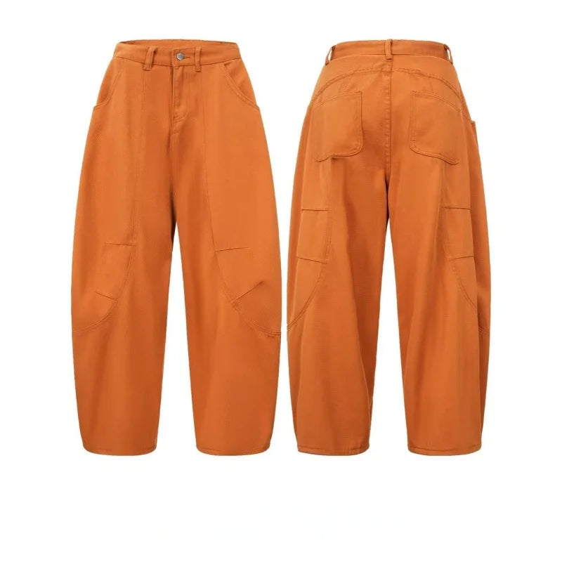Two pairs of burnt orange barrel leg pants laid flat