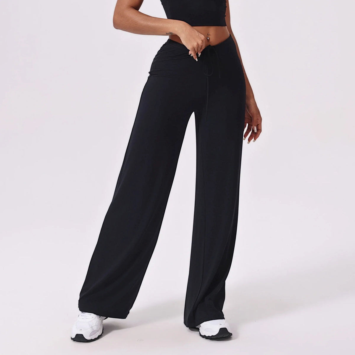 Black high waisted yoga pants, front view with white trainers