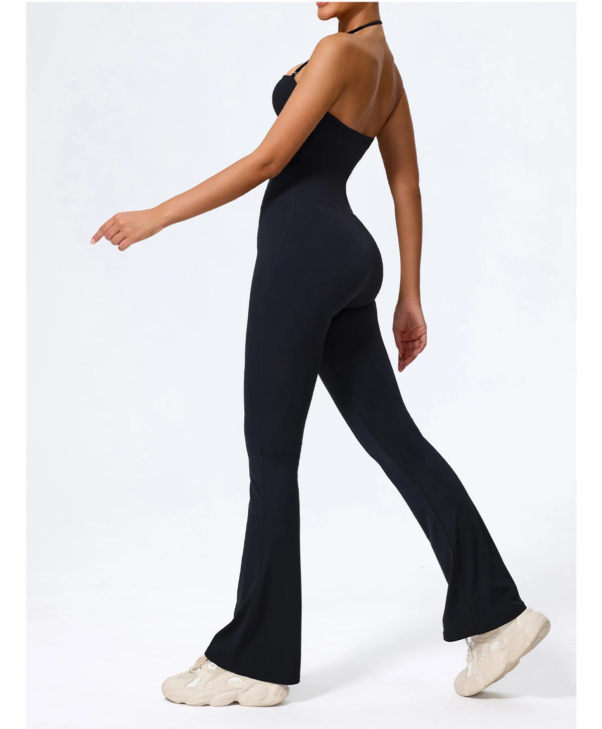 Black wide leg jumpsuit, side view with the flare in motion