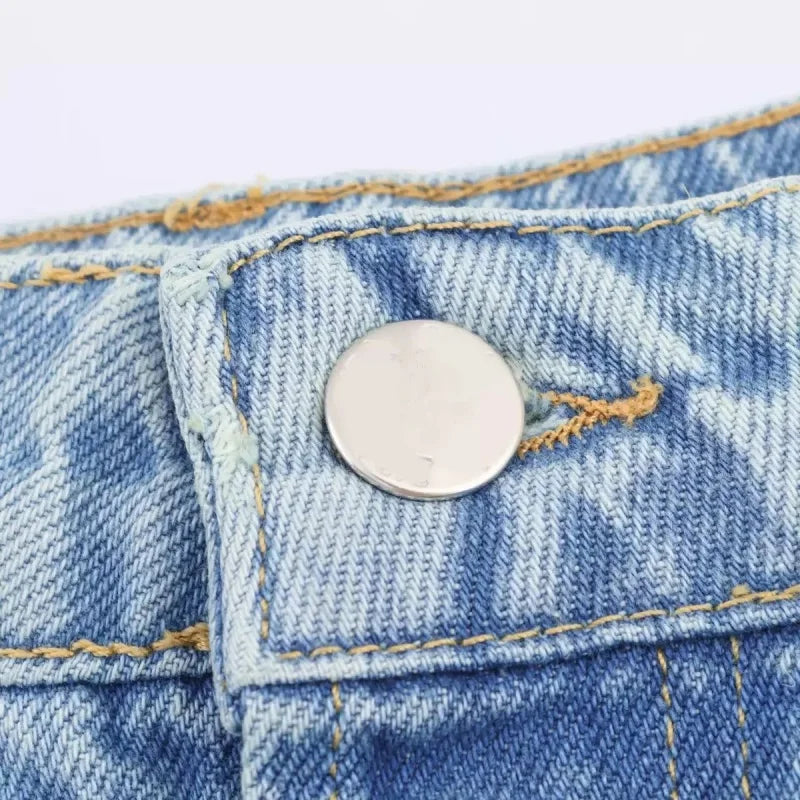 Metal button and waistband detail on light blue jeans
