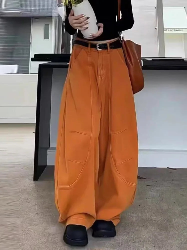 Burnt orange barrel leg pants on model, side angle showing curved leg