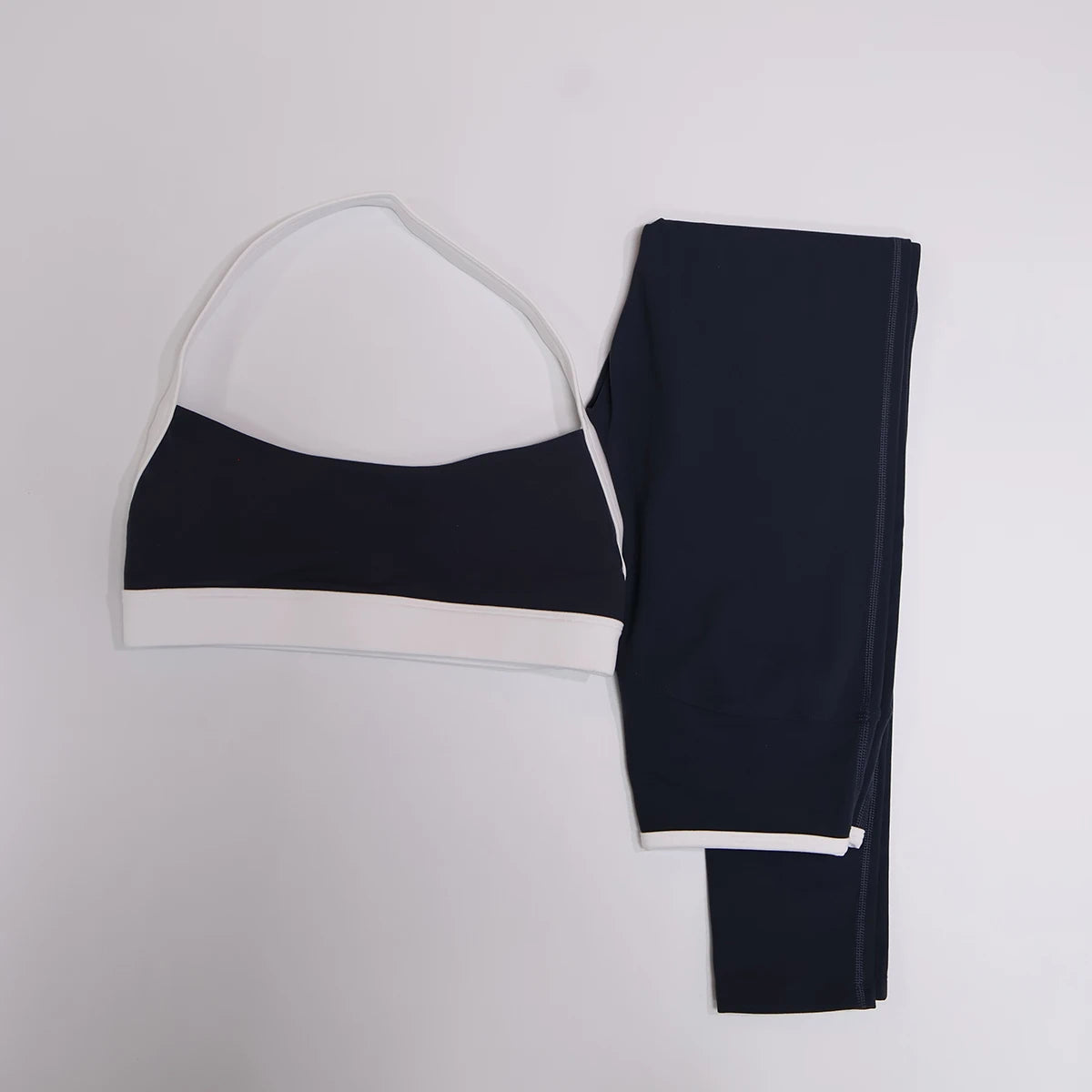 Navy blue leggings set with white contrast waistband, flat lay