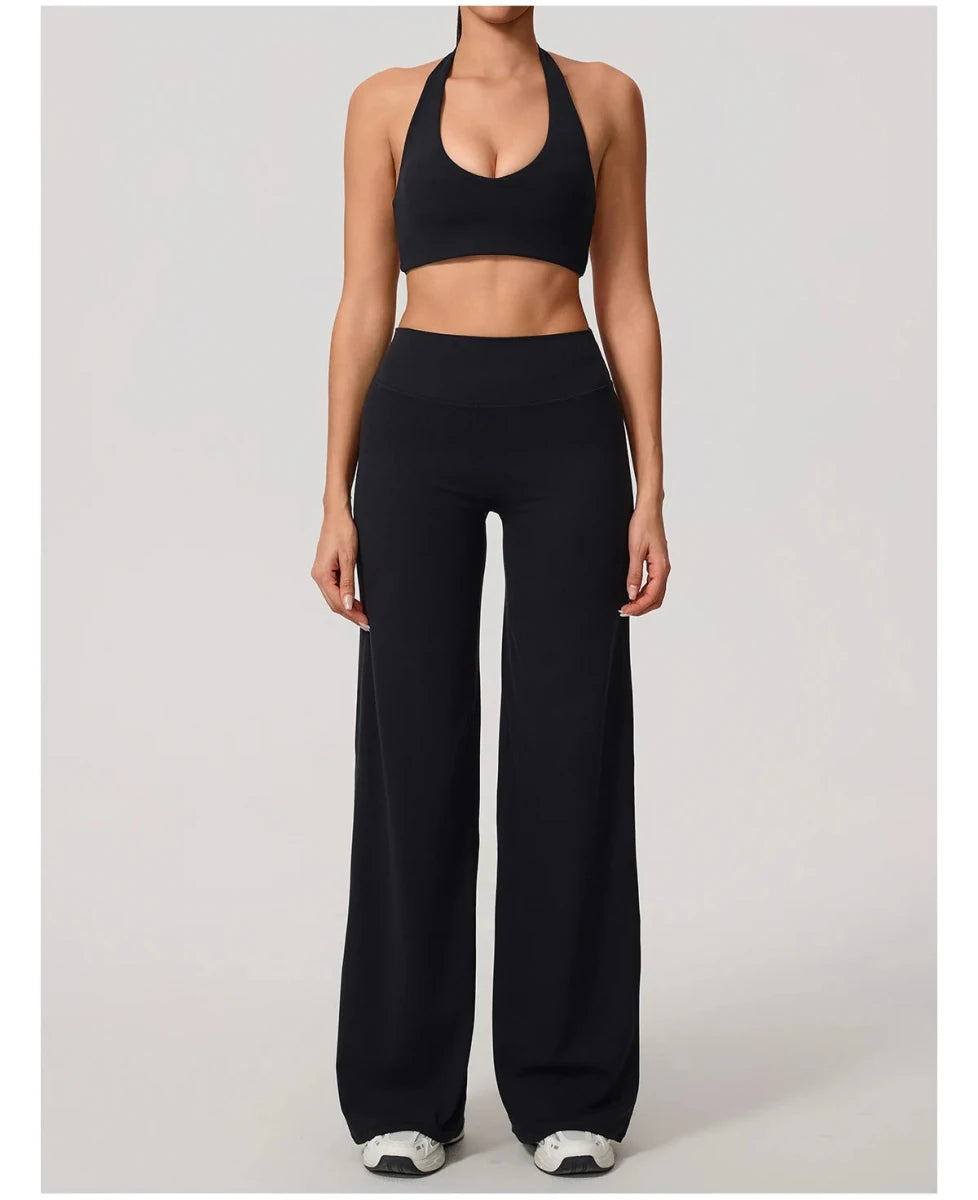 Black pilates outfit with open back halter bra and wide leg trousers, front